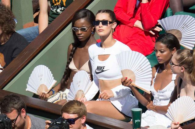 画像: ベラ・ハディッドは、友人らとおソロいの扇子。