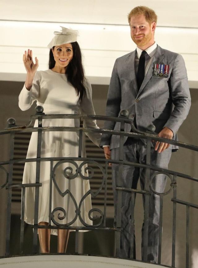 画像: ホテルのバルコニーから集まった群衆に手を振る夫妻。