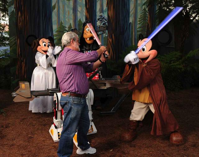 画像: シリーズ1作目と新3部作の監督を務めたジョージ・ルーカスと、『スター・ウォーズ』のコスプレをしたミッキーマウスとその仲間たち。