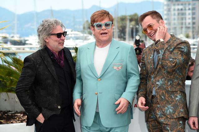 画像: 『ロケットマン』の物語の題材となったシンガーのエルトン・ジョン(中央)や主演のタロン・エガートン(右)とともにカンヌ国際映画祭のプレスイベントに登場したデクスター・フレッチャー監督(左)。