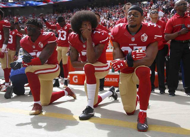 画像: 当時クォーターバックとして活躍していたサンフランシスコ・フォーティナイナーズのチームメイトと一緒にひざまずくコリン・キャパニック選手(中央)。