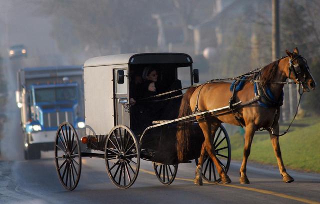 画像: ペンシルバニア州ランカスターで馬車で移動するアーミッシュの人々。