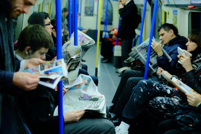 画像: ▲ロンドンの地下鉄は、日本でスマホをいじっている人くらいの割合で新聞を読んでいる人が多い。その感じが伝わるように意識してフレーミング、アングルとピント位置がポイントだ。■ 35mmF1.4 絞りF1.6 WB: 電球 ISO800