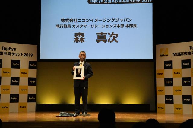 画像: ▲1985年当時に撮影された作品を手に挨拶する森真次本部長。