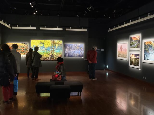 画像: 展示風景。会場には連日、多くの方が来場されています。米さんが撮影された風景写真の数々に、皆さん、目を奪われながら、笑顔がこぼれたり、「ずっと見ていられる!」と口にする方も。