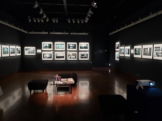 画像: ▲会場風景。会場では「建築の葬式」の様子を鈴木さんが切り取った写真と共に、同日、5号館で聴こえていた雨音や扉を開ける音、コピー機の音までも静かに耳に入ってきます。そして卒業生から集められた5号館の思い出も言葉となって、壁に写し出されていました。