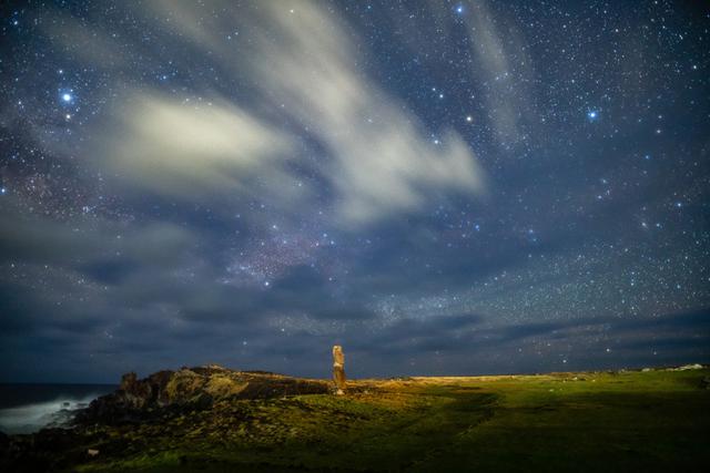 画像: 「ハンガ・キオエ、流れる雲とアルタイル」 ▲島の唯一の町、ハンガロアの近くに立つ単独のモアイだ。街灯りのために雲が白く輝いている。左上に見えている明るい星が日本でもおなじみの彦星・わし座のアルタイルだ。 ■ ソニーα7R III SIGMA 20mm F1.4 DG HSM Art 絞りF1.4 30秒 ISO3200 赤道儀による追尾撮影 Leeソフトフィルター3番