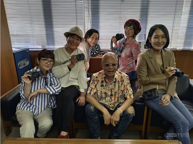 画像: ▲人気女子写真家諸氏に囲まれ、どこぞの将軍サマみたいに歓び組を侍らせるサカモト。奇跡の還暦+α。悔い改めよ!