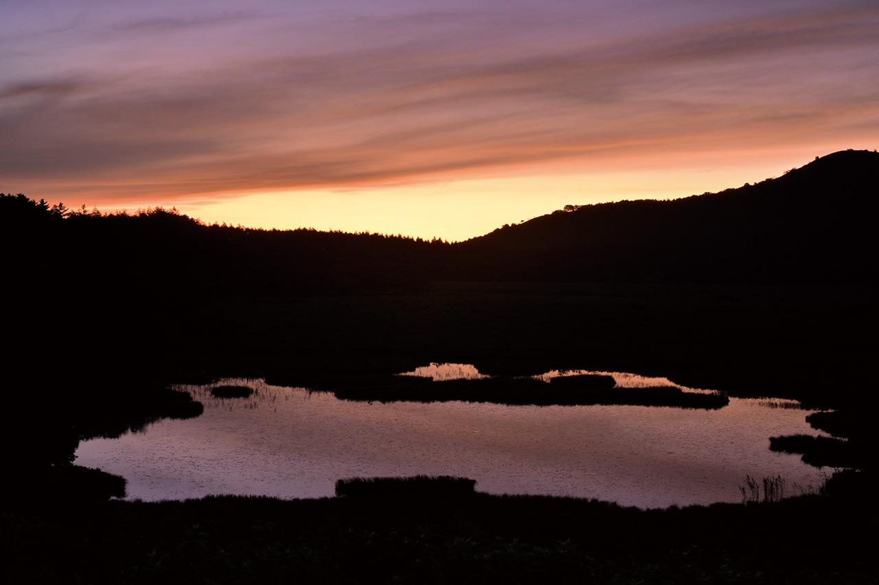 画像: 朝焼けに染まる八島ヶ池。ホワイトバランス「晴天」により、見た時の印象に近い朝焼け色を引き出せた。地平線付近の橙色から上部の藍色へのグラデーションがうまく描かれており、誇張のない自然な色合いだ。 ■NIKKOR Z 24-70mm f/4 S 絞り優先AE(絞りF16 1秒) マイナス0.7露出補正 ISO200 WB:晴天