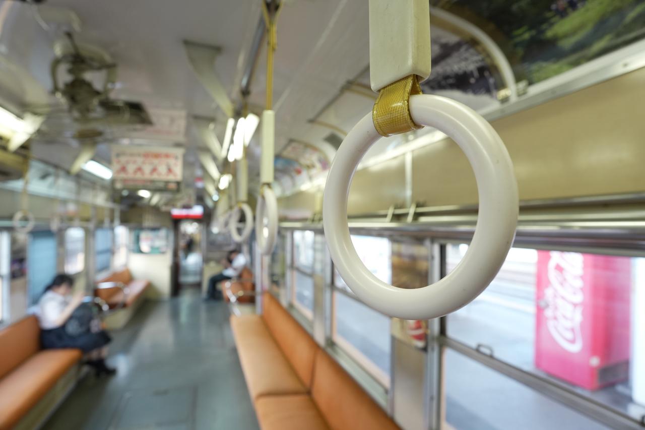 画像: 吊革に掴まり車内をぼんやり見下ろしているようなイメージ。絞り開放では背景がボケ味が大きすぎたので、乗客の存在感を少し強めつつ、かつプライバシーを侵害しない程度の被写界深度になるようにして撮影。 ■ソニーZV-E10 Ⅱ 絞り優先AE（F4　1/50秒）　プラス1.3露出補正　ISO800　WB:オート