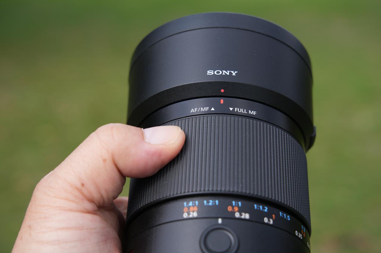 画像: レンズ先端方向にスライドした時が通常のAF撮影（AF合焦後のピント調整可能なダイナミックマニュアルフォーカスなども含む）。後方（マウント方向）にスライドするとフォーカスレンジリミッターの設定状況なども関係なく全域でピントリング回転のMF撮影に切り替わる。