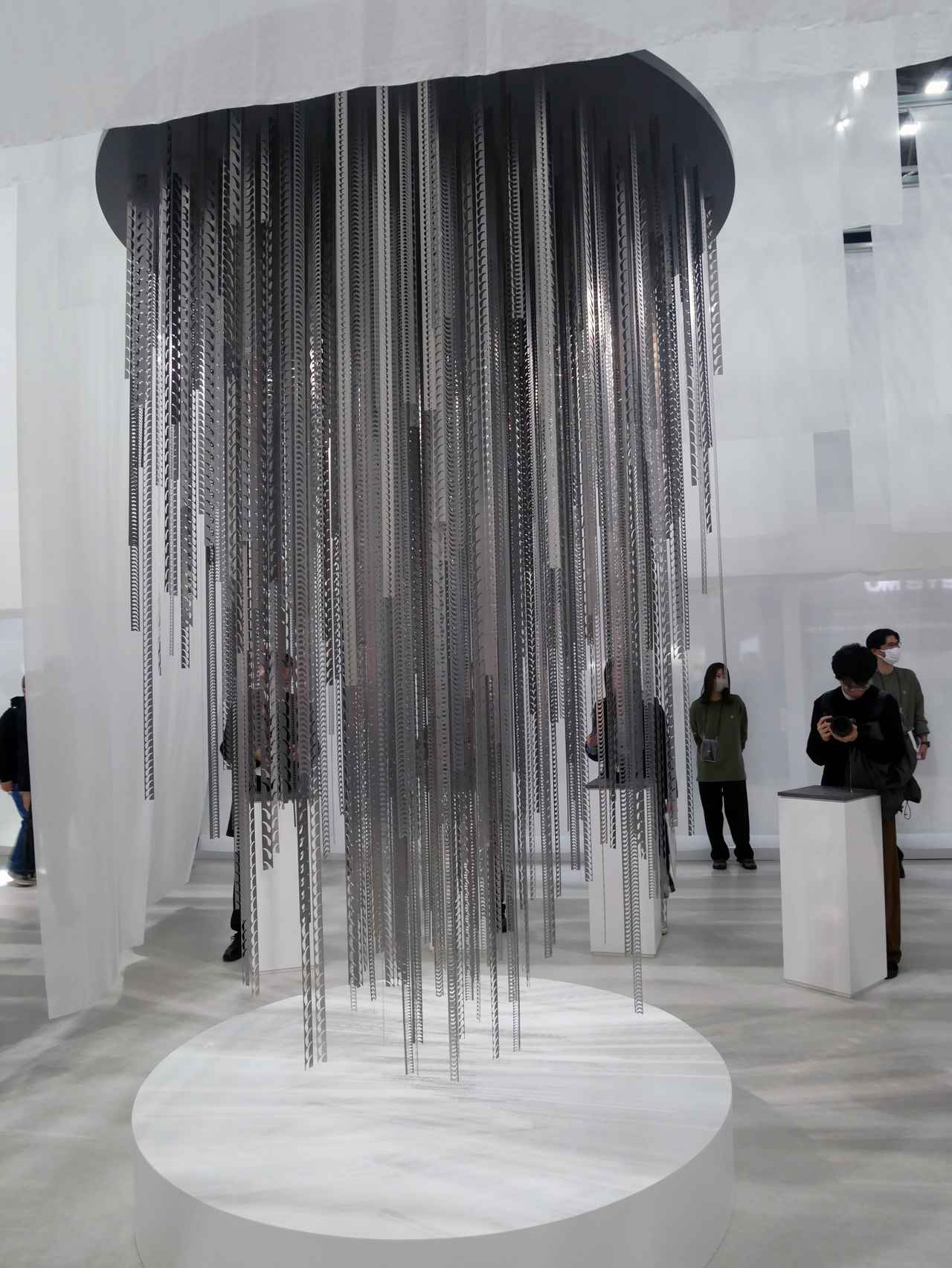 画像: ブースの中央にで〜ん!と吹き抜けのようにつるされたオブジェ。レンズ絞りの抜き材を使ったそうですが、現代アートにも思える様は、シグマBFの美学に通じる!?