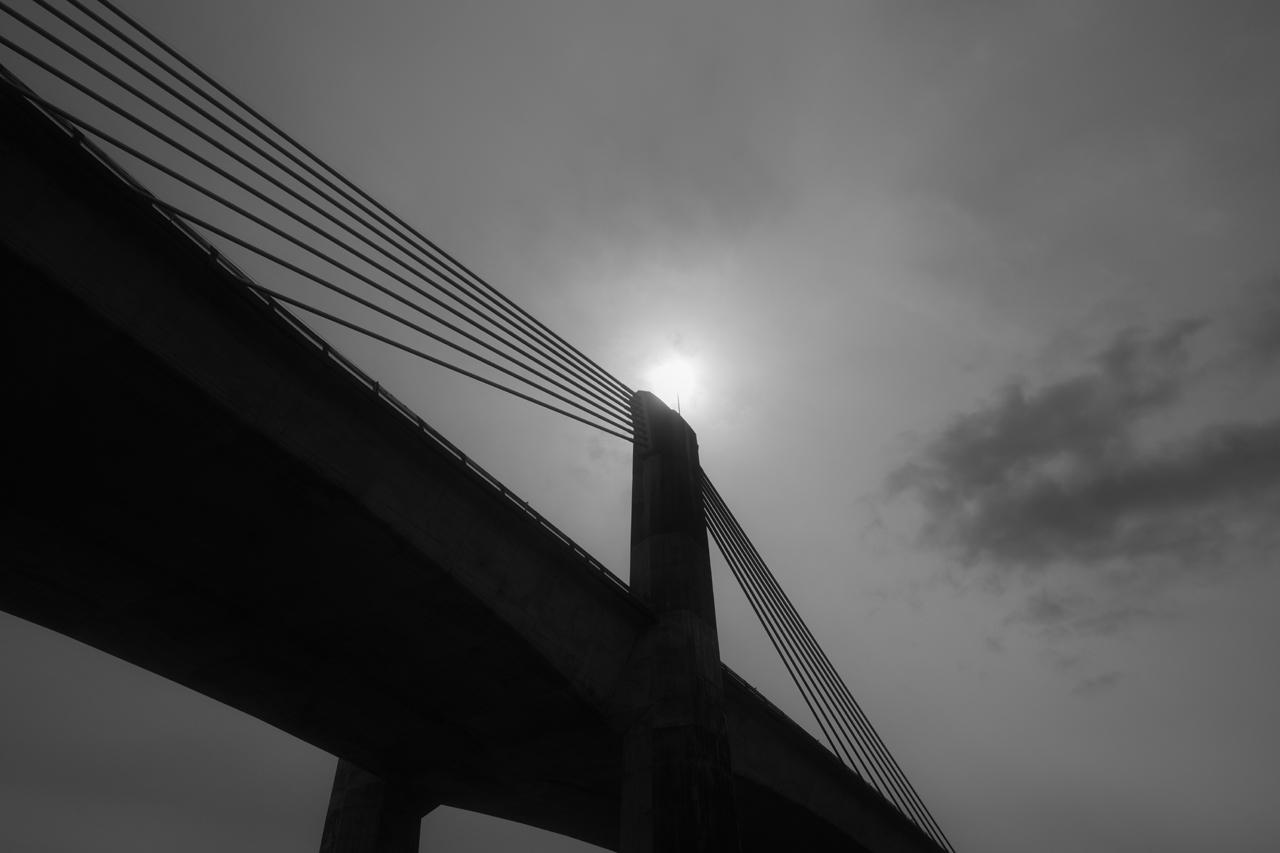 画像: ［スタンダード］でもハイコントラストに仕上がる逆光シーン。［ソフト］でちょうど良い調子になった。太陽はギリギリまで白飛びを避け、橋は黒くつぶれず階調を残している。橋のラインは真っ直ぐに描かれ、輪郭も縁取りなど不自然さは全く見られない。 ■絞りF5.6　1/2000秒　ISO320　※イメージコントロール：ソフト　※赤色フィルター：オン