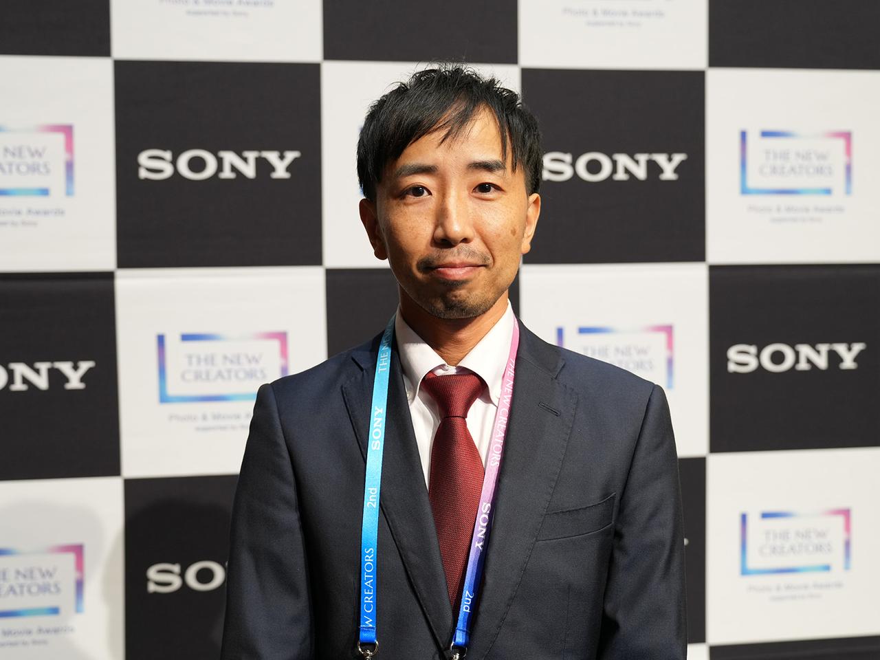 画像: 写真作品グランプリ受賞の坪井智洋さん。日頃から写真・動画撮影と農業を兼業しており、いただいた名刺にも「Farmer／Photographer」と書かれていた。今回の作品づくりに向けた撮影は、「これまでの中で最もハードな部類に入る」とも語ってくれた。