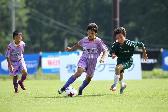画像: 戸祭博登(新座片山犬コロFC)のドリブルに必死に食い下がるフットボールコミュニケーション守備陣