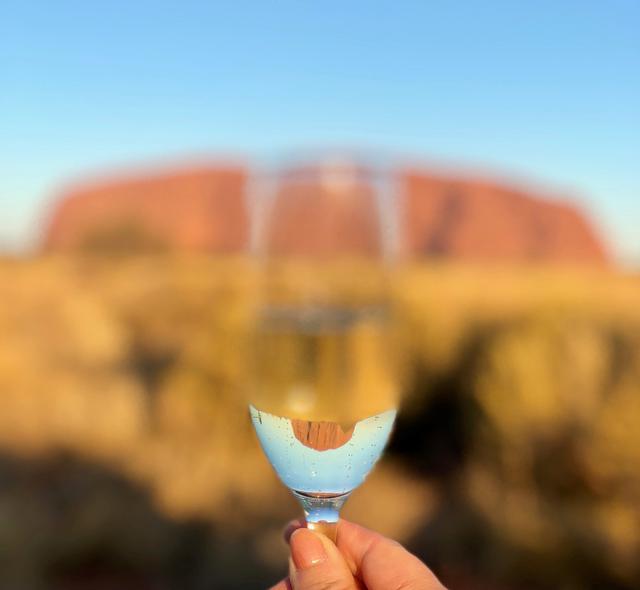 画像: ウルルに到着!スパークリングワインを片手に「乾杯!」グラスに映る「逆さエアーズロック」で記念撮影です♪