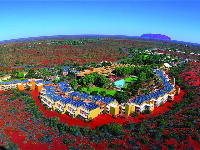 画像: エアーズロックリゾート空撮 ©Voyages Indigenous Tourism Australia ホテルは平家も多くあるが最大でも3階建。景観を遮らないよう丘の高さ以上の建物は建てられない。ちなみに、この画像の中にスタッフの住宅はうつっておりません。(数ヶ所ある中で1ヶ所は、画像の左側の方にあります。あと数cmくらい映る広角ショットでしたら入っていました(笑)。いや、あえて映らないようにしてるのですかね)