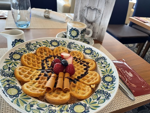 画像: ノルウェースタイルのワッフル（筆者撮影） 素敵なお皿とティーカップもノルウェーの老舗陶磁器ブランドFiggjo（フィッギオ）の食器、「Tor　Viking」をバイキングクルーズオリジナルとして復刻させたもの。