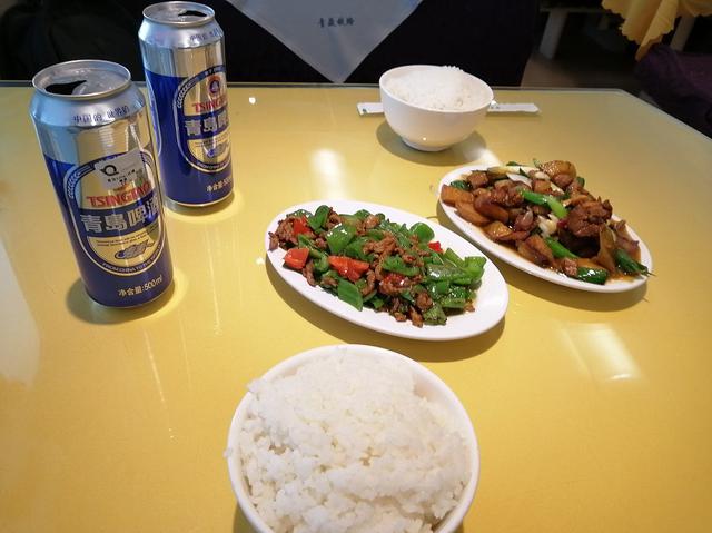 画像: 空いた食堂車にて青椒肉絲とごはんの夕食。左上の青島啤酒(ビール)はこの後筆者を苦しめることになる