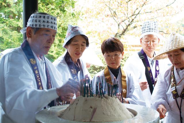 画像: 先達から作法の案内を聞きながらお参りをするお客様