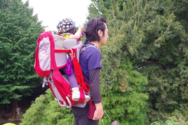 画像: ベビーキャリーを背負ったところ 背面や子どもの足の間に、若干の荷物収納スペースがついています