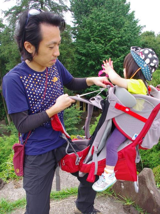 画像: 子どもを乗せたベビーキャリーが落ちたり転がったら危険。 背負う時は、重いザックを背負う時と同じように... ・中腰になる ・ひざの上にザックを乗せる ・身体をねじってショルダーベルト(肩ひも)に片方ずつ腕を通す の順番で慎重に背負いましょう。