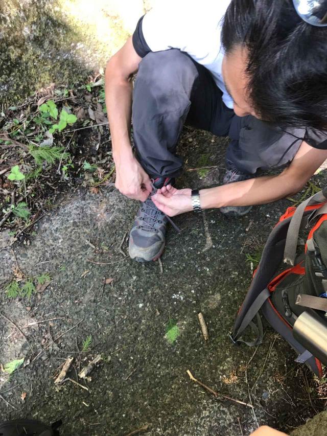 画像: 登山ガイドの鷲尾さん。靴紐を結び直し中です。