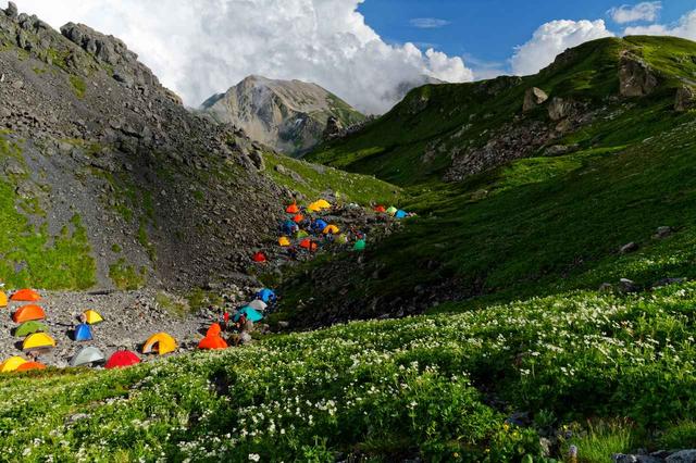 画像: テント泊での日本アルプス縦走。 山小屋泊に比べて費用は抑えられる代わりに、テント・食糧・炊事道具・寝具などを全て自分で背負わないといけないため、かなりの重装備で歩く体力も必要とされる。