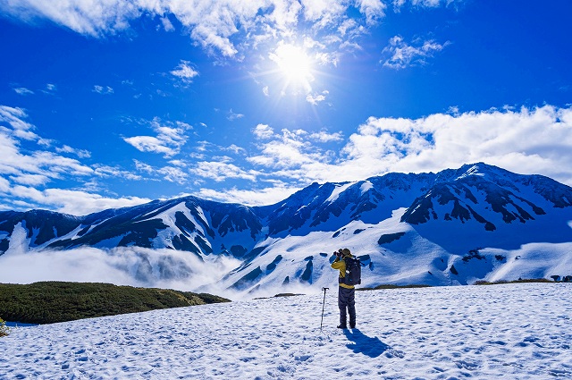 画像: 3,000m級の立山連峰に囲まれた室堂を歩きます。 室堂付近にある、みくりが池に、雪を纏った立山連峰が反射する光景は一見の価値ありです。 雪の上は普通の靴では足が埋まってしまって歩きにくいですが、スノーシューは浮力があるので、深い雪でも楽々歩けます。夏は歩けないようなところも雪で埋まって歩けるようになり、非日常体験がスノーシューでは味わえます。