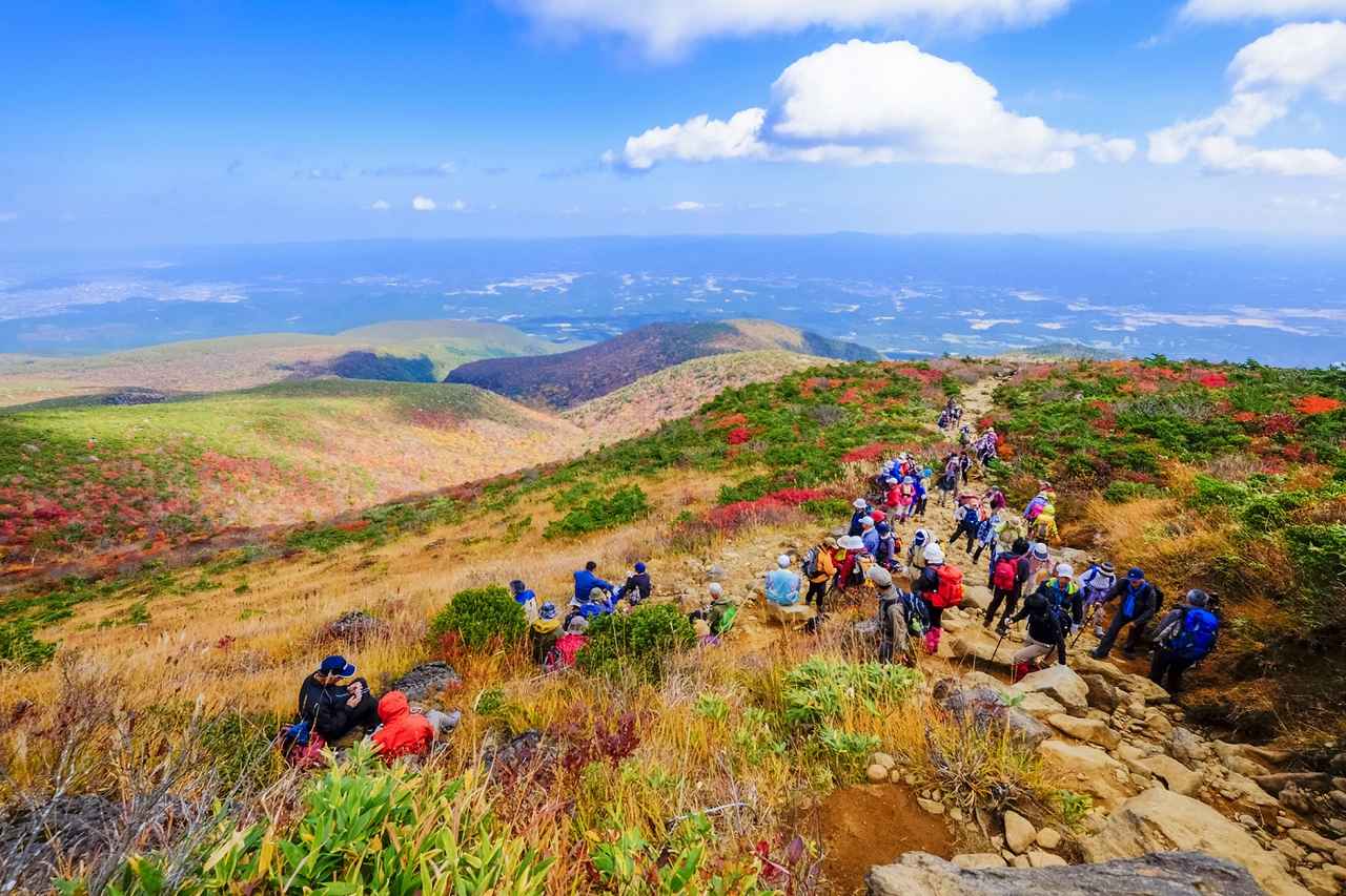 画像: 安達太良山の紅葉に染まる登山者