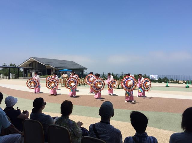 画像: 鳥取砂丘を背景に「砂丘テラス」にて行われた鳥取市観光協会連による「しゃんしゃん傘踊り」の様子