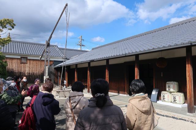 画像: 酒蔵館の入り口には酒作り用の水を汲み上げるのに使われた木製の大型汲み上げ機が展示されています。