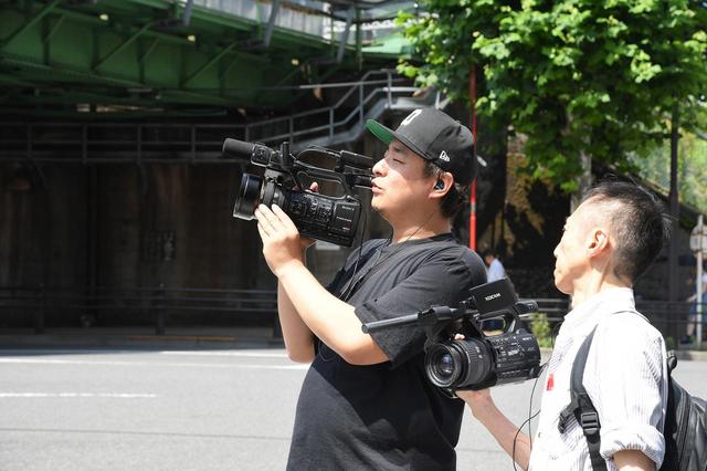 画像: 重いカメラを操る熟練のカメラマン