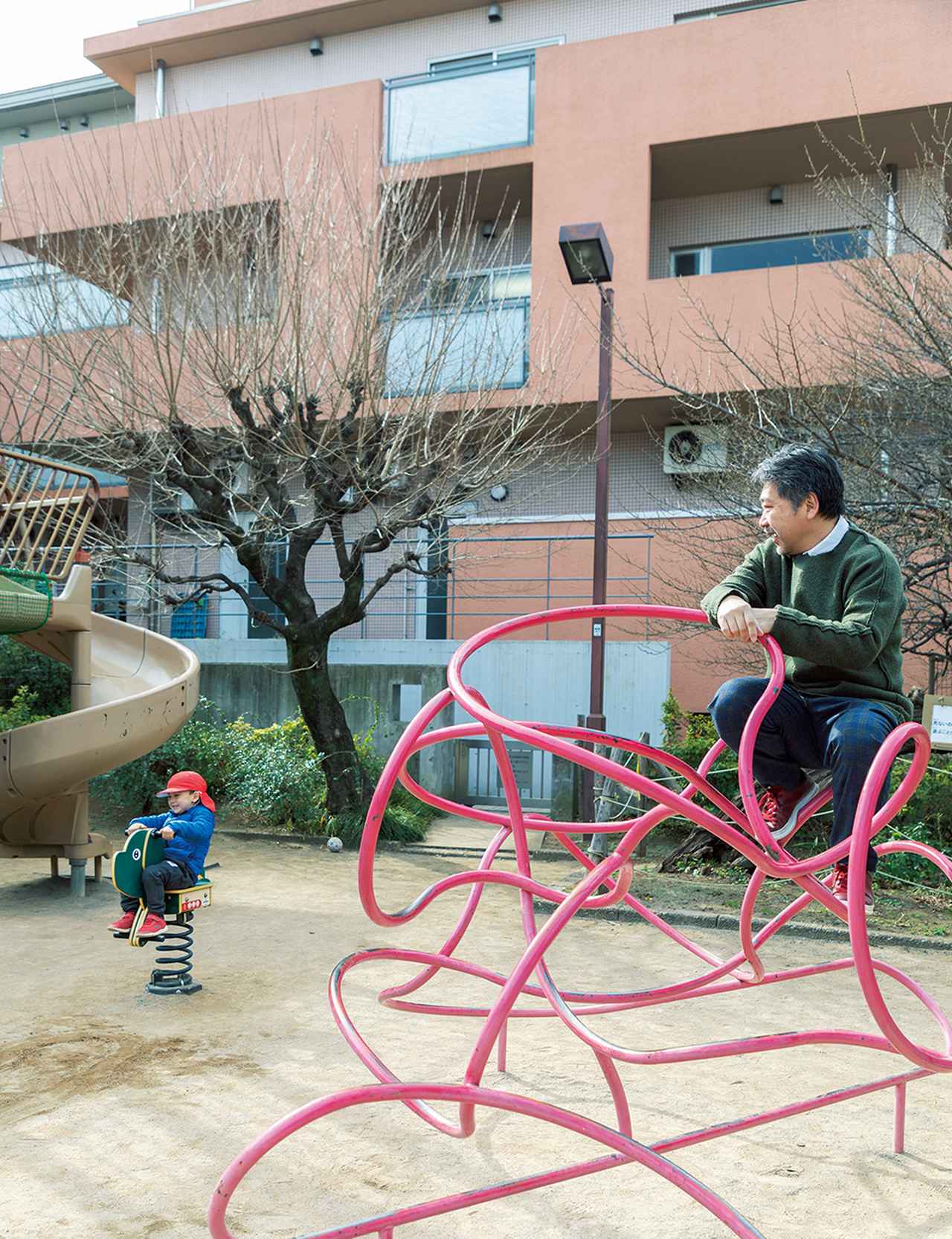 画像: 冬の晴れ間、カメラマンの要望にこたえ、是枝はコートを脱ぎ捨て、ひととき遊具と戯れた