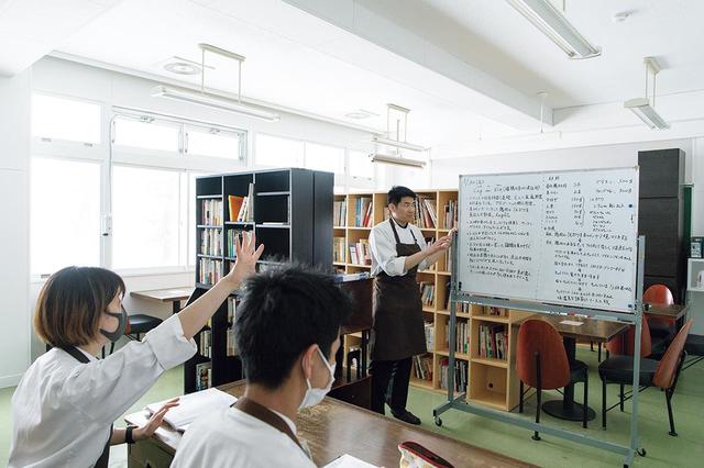 画像: この日の「美瑛料理塾」のテーマは「コック・オー・ヴァン(鶏の赤ワイン煮込み)」。調理実習前に、料理が作られた土地の背景や農産物についての授業を受ける。廃校を活用した建物内には、料理関係の良書がずらりと並ぶ図書室もある