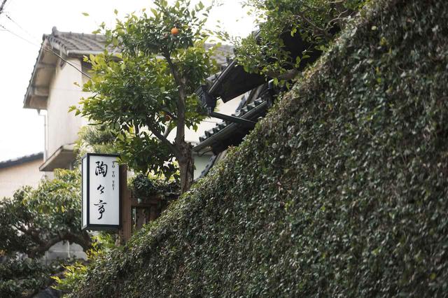 画像: 蔦に覆われた塀越しに、歴史ある建物の趣が顔を覗かせて
