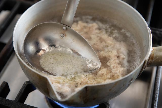 画像: だしを作る。昆布水(昆布は取り除く)を温め、沸騰してきたら鶏ひき肉を入れて混ぜてほぐす。アクをすくう。