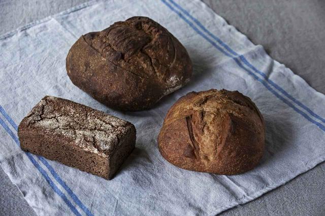 画像: 奥は噛むほどに味の広がりを感じるカンパーニュ。右はノルマンディーのスタイルに倣ったブリオッシュ。ハチミツや無塩バター、オリーブオイルなどと相性がよい。左はその名もライ麦100%、デンマークの基本のロブロを忠実に簡素な作り方で再現