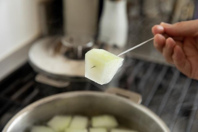画像: 冬瓜に透明感が出て、竹串を刺してすっと通ったら醤油を加えて混ぜる。枝豆を入れ、いったん煮立ててから弱火にする。