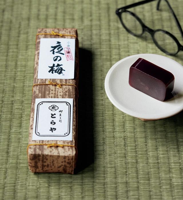 画像: 文豪たちが筆をふるったのがどこの品か記録はないが、羊羹といえば「とらや」。右は、その名を『古今和歌集』の一首「春の夜の闇はあやなし 梅の花 色こそ見えね 香やは隠るる」にちなむ「夜の梅」。切り口の小豆は闇に咲く梅の花。崇高なたたずまいに惚れぼれ。「竹皮包羊羹 夜の梅」¥3,024 とらや TEL.0120-45-4121 眼鏡¥49,500/モスコット モスコット トウキョウ TEL.03-6434-1070