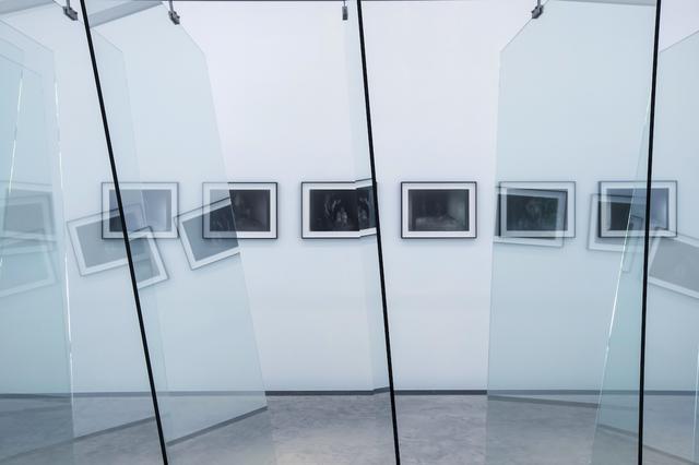 画像: 展示室「Raum 2」にて。反射ガラスを絶妙な傾斜で並べた作品《8枚のガラス》越しに、リヒターが撮影したモノクロームの写真作品が幻想的な空間を作り出す