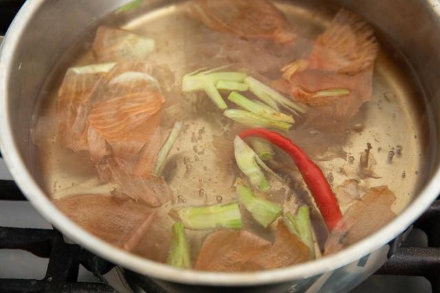 画像: 鍋に1.5ℓほどの水を入れ、火にかける。煮立ったら、玉ねぎの皮と香菜の根元、赤唐辛子、塩を入れて、軽く煮立つくらいの火加減で15分ほど煮込む。