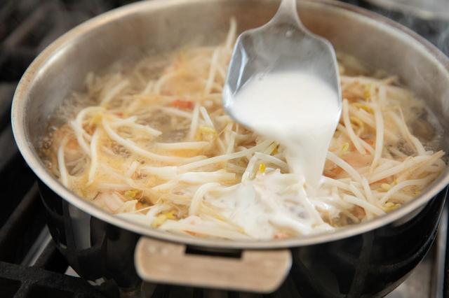 画像: ココナッツミルクを加えて、具材が浸かるくらいに水（材料外）も加える。味を見て、残りのナムプラーを少しずつ加え（塩味が足りていれば全部使わなくてもいい）、煮立てないように軽く煮る。