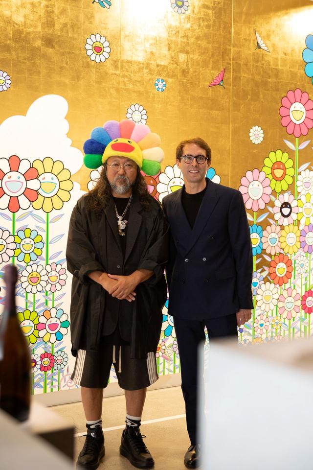 画像: 醸造最高責任者のヴァンサン・シャプロン(右)と村上隆(左)。会場には、この日のためだけに村上の大作《金色の空の夏のお花畑》が展示された