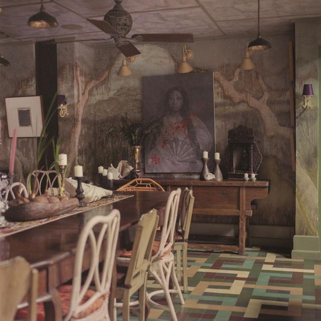 画像: ダイニングルームでは、フィリピン人アーティスト、シーフレッド・ギラランの絵画が、中国の地方でつくられたアンティークの木製テーブルの上に飾られている。19世紀に製作されたナラ材のダイニングテーブルを囲むのはふぞろいな椅子の数々。風景画の壁画はロドリゲスがさまざまな種類の漆喰を駆使して描いた。