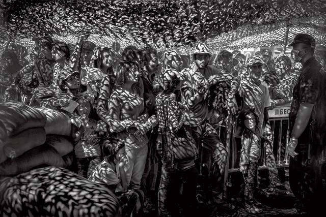 画像: 報道写真を元にした別の絵画作品。2015年にセルビアの受け入れセンターで手続きを待つシリアとイラクからの難民たちを描いている。 ROBERT LONGO, “UNTITLED (SYRIAN AND IRAQI REFUGEES WAIT IN LINE FOR DOCUMENTS AT PROCESSING CENTER IN PRESEVO, SERBIA; THURSDAY, AUGUST 27, 2015; BASED ON A PHOTOGRAPH BY SERGEY PONOMAREV),” 2018, CHARCOAL ON MOUNTED PAPER, COURTESY OF ROBERT LONGO STUDIO © 2025 ROBERT LONGO/ARTISTS RIGHTS SOCIETY (ARS), NEW YORK