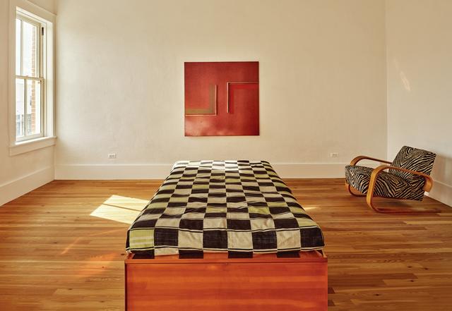 画像: (ON WALL) JOHN CHAMBERLAIN, “UNTITLED,” 1964, METAL AND LACQUER WITH REFLECTIVE FLAKE ON FIBERBOARD © 2025 FAIRWEATHER & FAIRWEATHER LTD./ARTISTS RIGHTS SOCIETY (ARS), NEW YORK; (ON FLOOR) DONALD JUDD BED © 2025 JUDD FOUNDATION/ARTISTS RIGHTS SOCIETY (ARS), NEW YORK