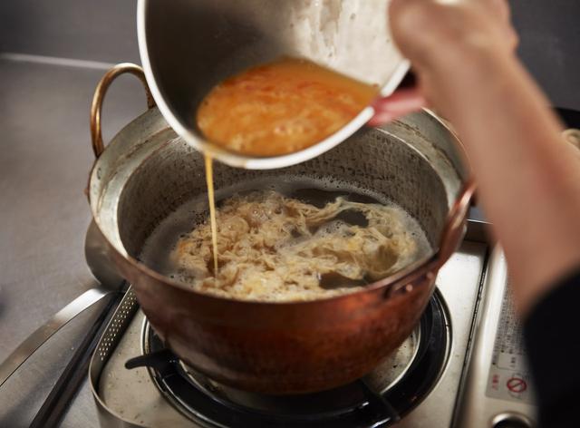 画像: ５ だしが静かに煮立っている状態にし、卵液を細く落としていく。決して混ぜないようにして、ふわふわと卵が浮かんでくるのを待つ。