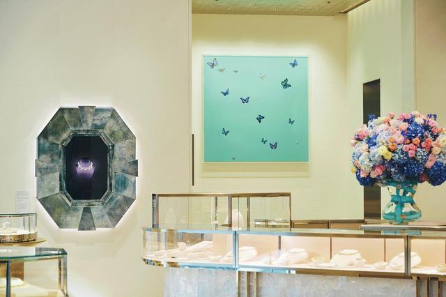 画像: １階フロア。奥には英国の現代アーティスト、ダミアン・ハーストの作品《TiffanySuperb》。蝶の標本がティファニー ブルーのタブローの上を舞う。