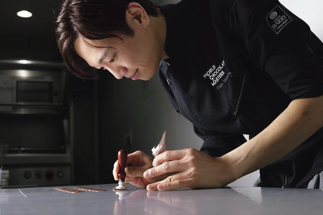 画像: 「小さな一粒の中に、舌ざわり、アロマ、素材のハーモニーといくつもの要素がレイヤーとなって、まるで小宇宙があるかのようだと感じたことが、チョコレートに魅せられたきっかけでした」と松田詢吾シェフ。現在は札幌の「ショコラティエ マサール」にスーシェフとして勤務しており、「サロン・デュ・ショコラ」には同店と自身のブランドのダブルネームで出品。2026年春に千歳市に自らの店舗をオープン予定。北海道を拠点に選んだのはベルギーに近い気候、食材のポテンシャルの高さ、妻の出身地であることが理由だとか。 PHOTOGRAPH BY SHUSAKU NAGAHAMA